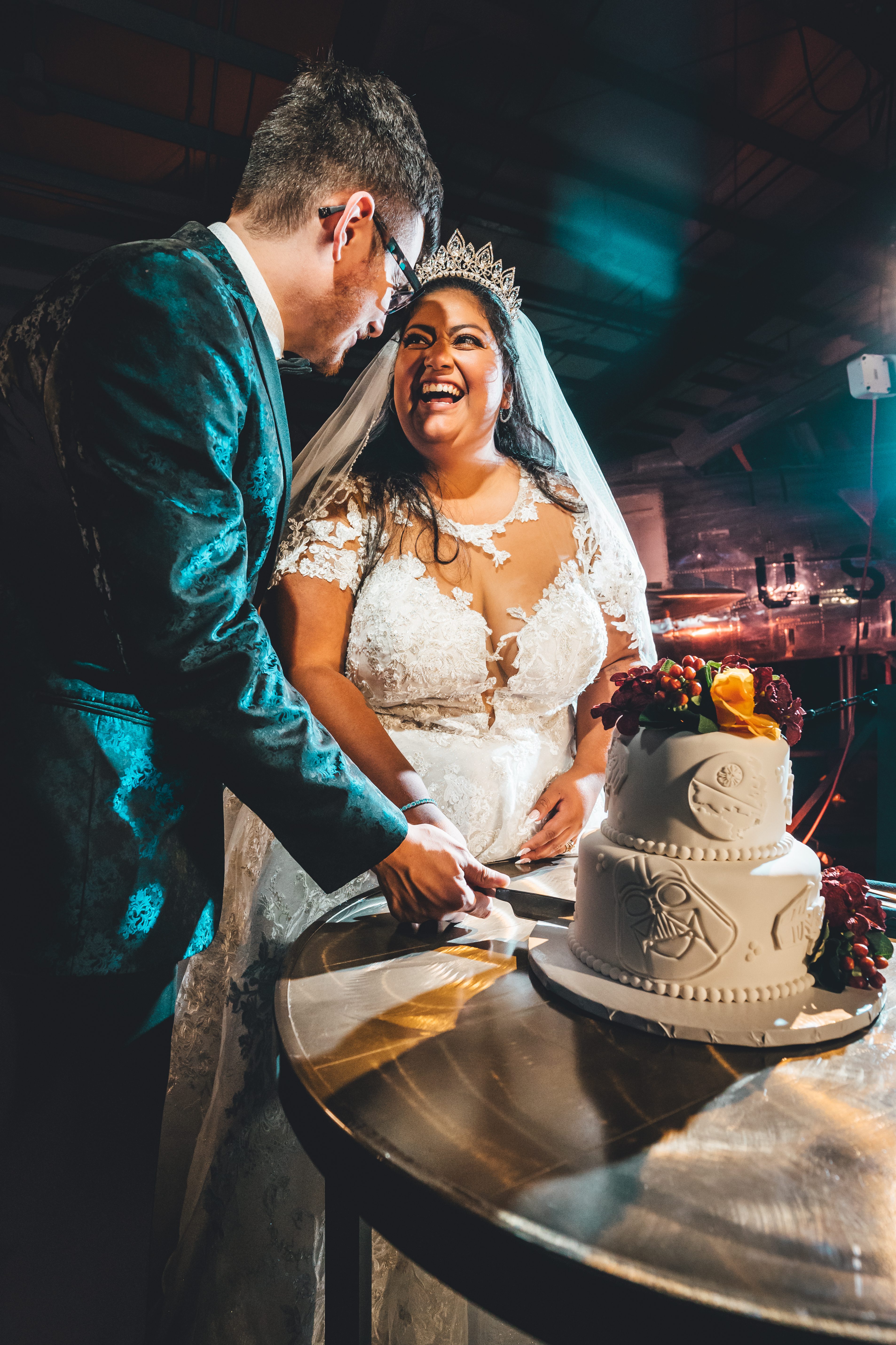 A couple cuts their Star Wars wedding cake embossed with Darth Vader and the Death Star