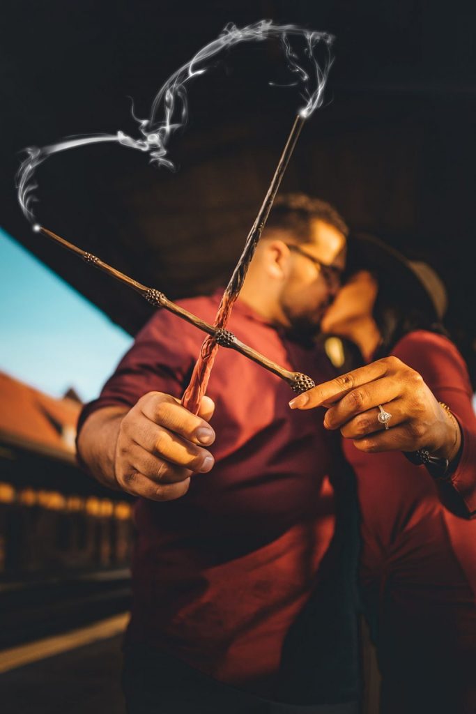 An engaged couple crosses wands during their Harry Potter engagement session