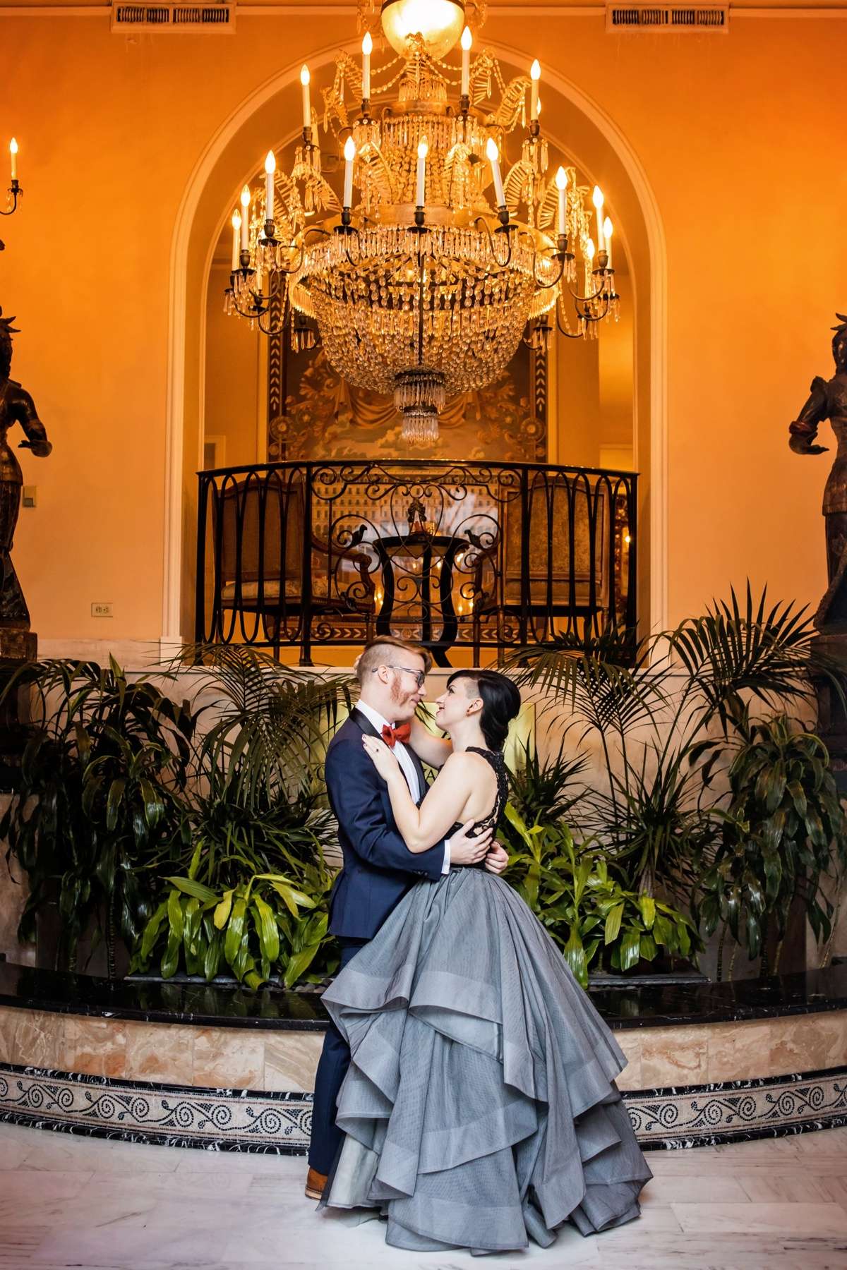 A couple embraces beneath a chandelier at their Star Wars themed wedding
