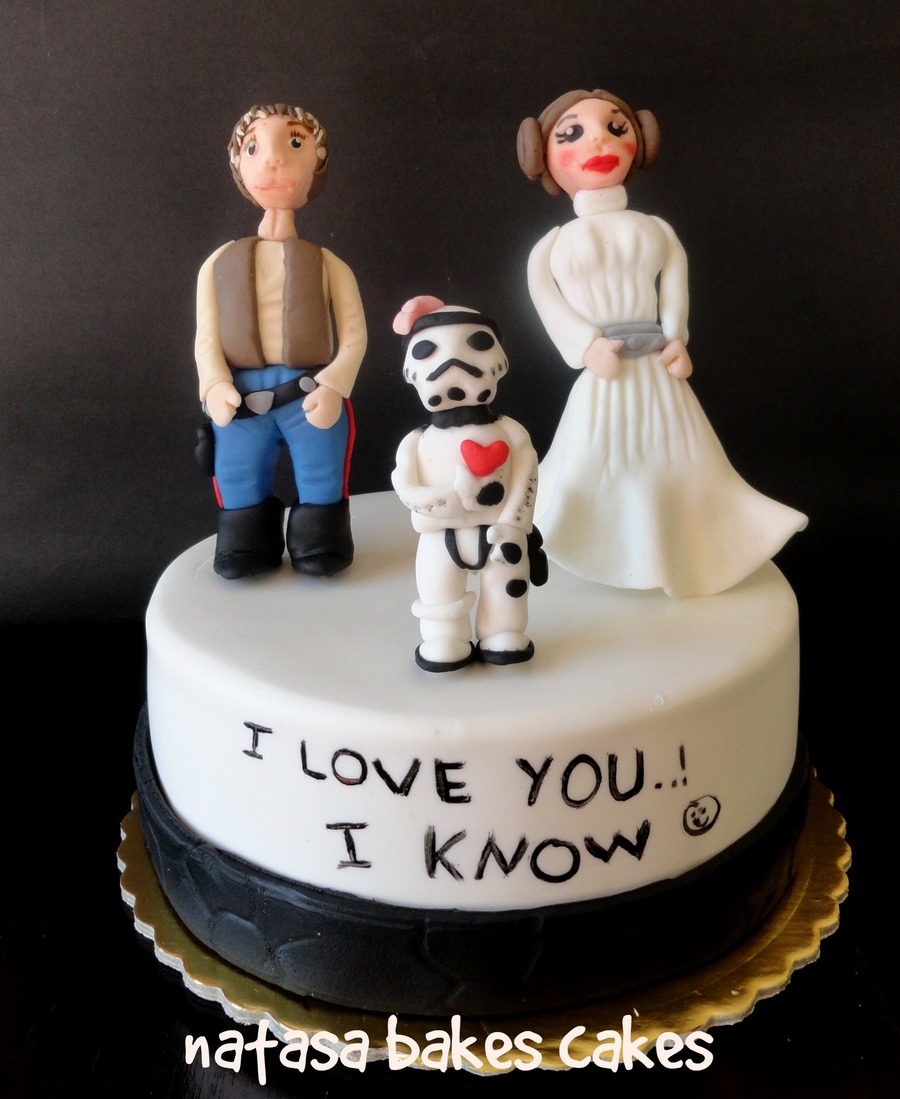 White cake with I love you, I know written in icing and Han Solo and Leia figures on top
