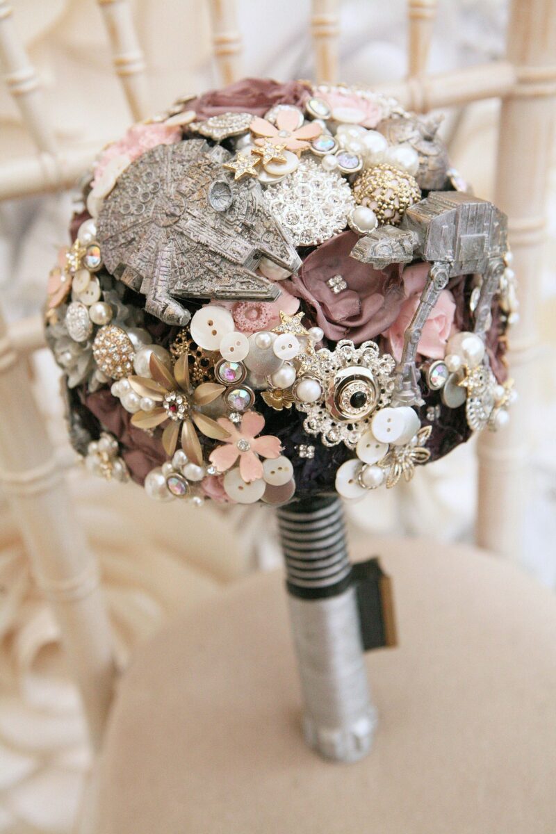 Star Wars brooch bouquet with Millennium Falcon and AT-AT on a lightsaber hilt