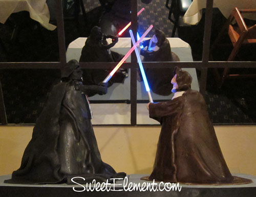 Sculpted Darth Vader and Obi-Wan cake figures dueling with glowing lightsabers