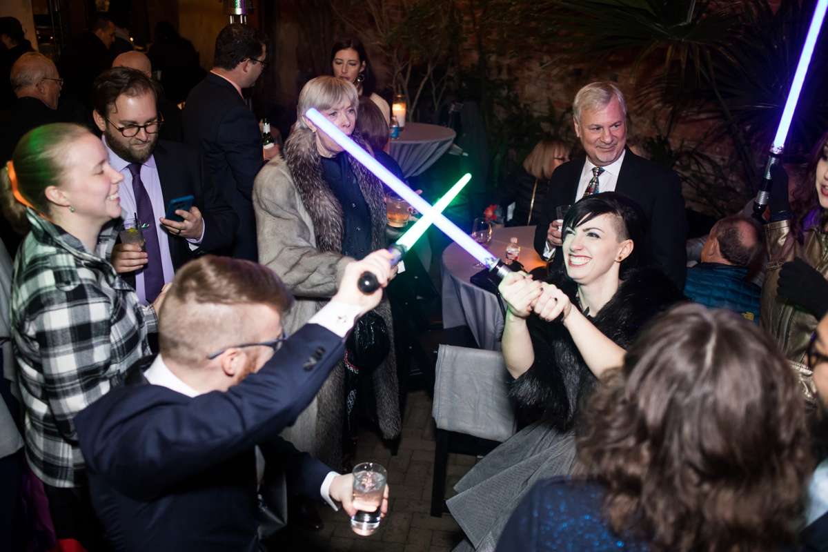 Wedding guests break into a lightsaber duel between the reception tables